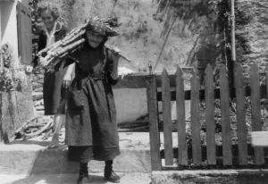 Donna con fascio di legna sulle spalle in località Grovella (1957)
